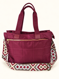 Bolso acolchado granate con asas y correa multicolor sobre fondo claro